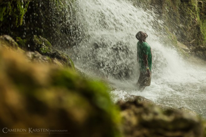 In a moment of solitude, a pilgrim enjoys the cool healing waters of Saut d'Eau.