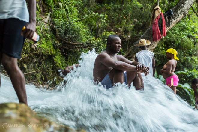 A pilgrim at Saut d'Eau sits still in the rushing waters.